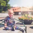 toddler sitting on wooden bench