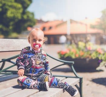 toddler sitting on wooden bench