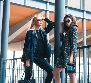 woman in blue denim jacket standing beside woman in black and white floral long sleeve shirt