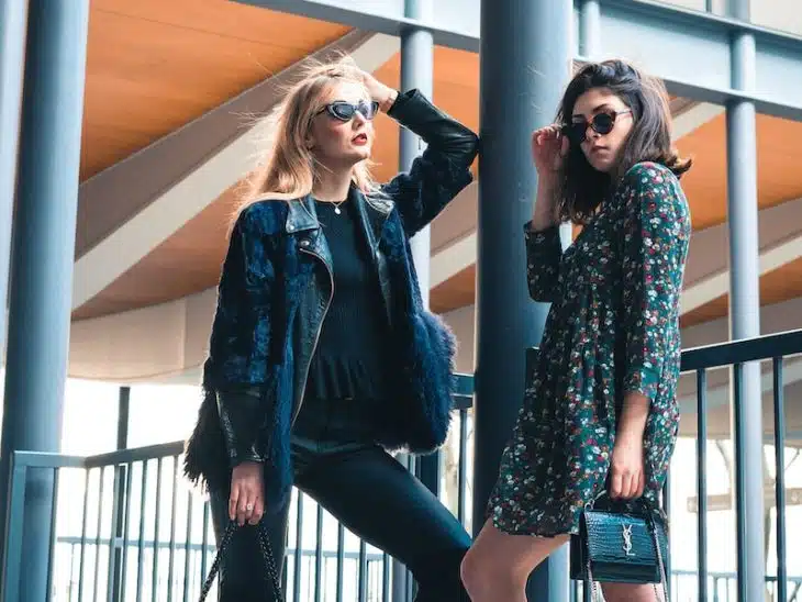 woman in blue denim jacket standing beside woman in black and white floral long sleeve shirt