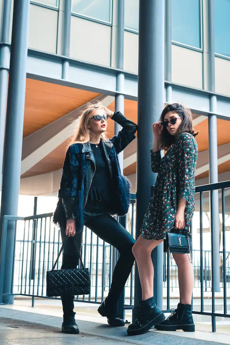 woman in blue denim jacket standing beside woman in black and white floral long sleeve shirt