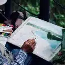 man holding brown and black pen painting seashore