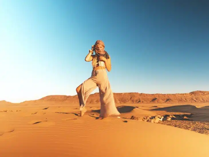 woman in brown pants standing on desert